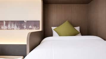 A hotel room with a bed, a nightstand, and a wall-mounted artwork.