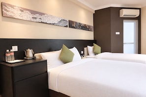 Une chambre d’hôtel avec deux lits, une table de chevet, une machine à café et un appareil de climatisation.
