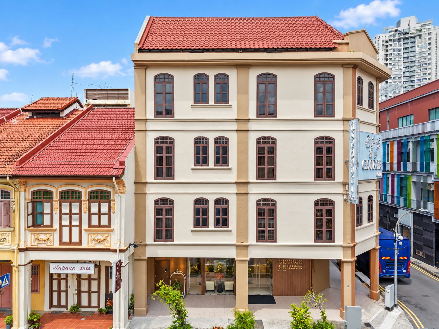 Um edifício de vários andares com telhado de telhas vermelhas, janelas amplas e uma fachada com a inscrição 'George'.