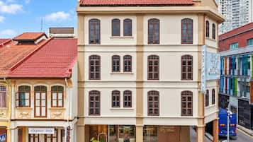 Um edifício de vários andares com telhado de telhas vermelhas, janelas amplas e uma fachada com a inscrição 'George'.