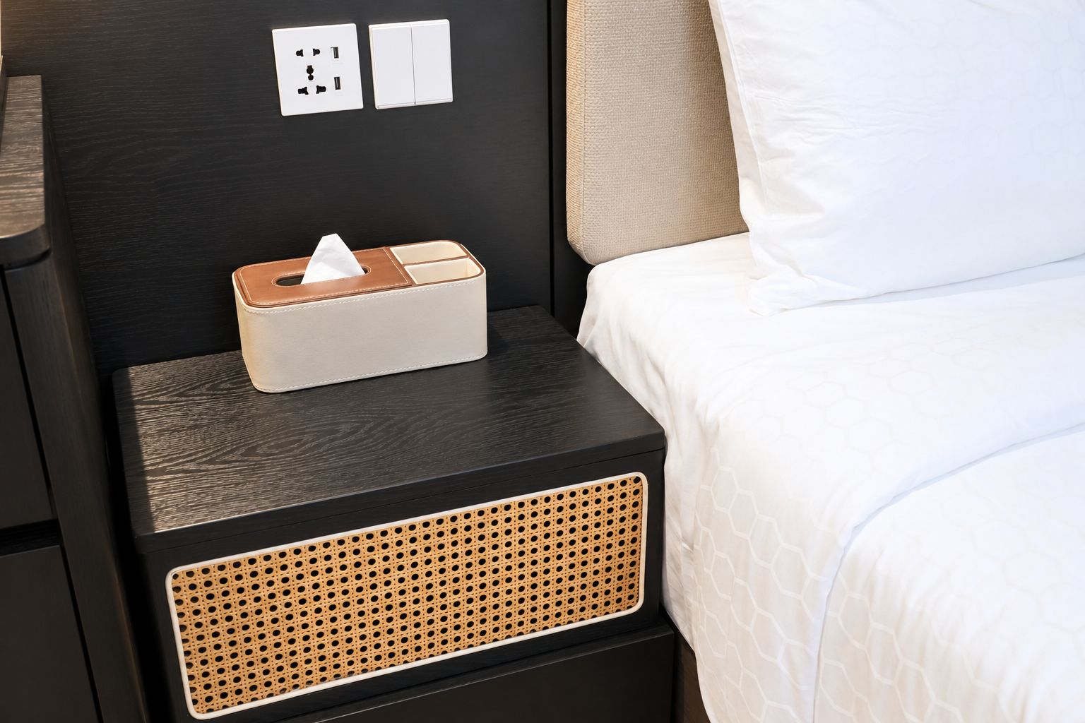 Una cama bien hecha con una almohada blanca y una manta blanca.