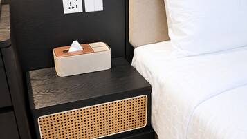 Una cama bien hecha con una almohada blanca y una manta blanca.
