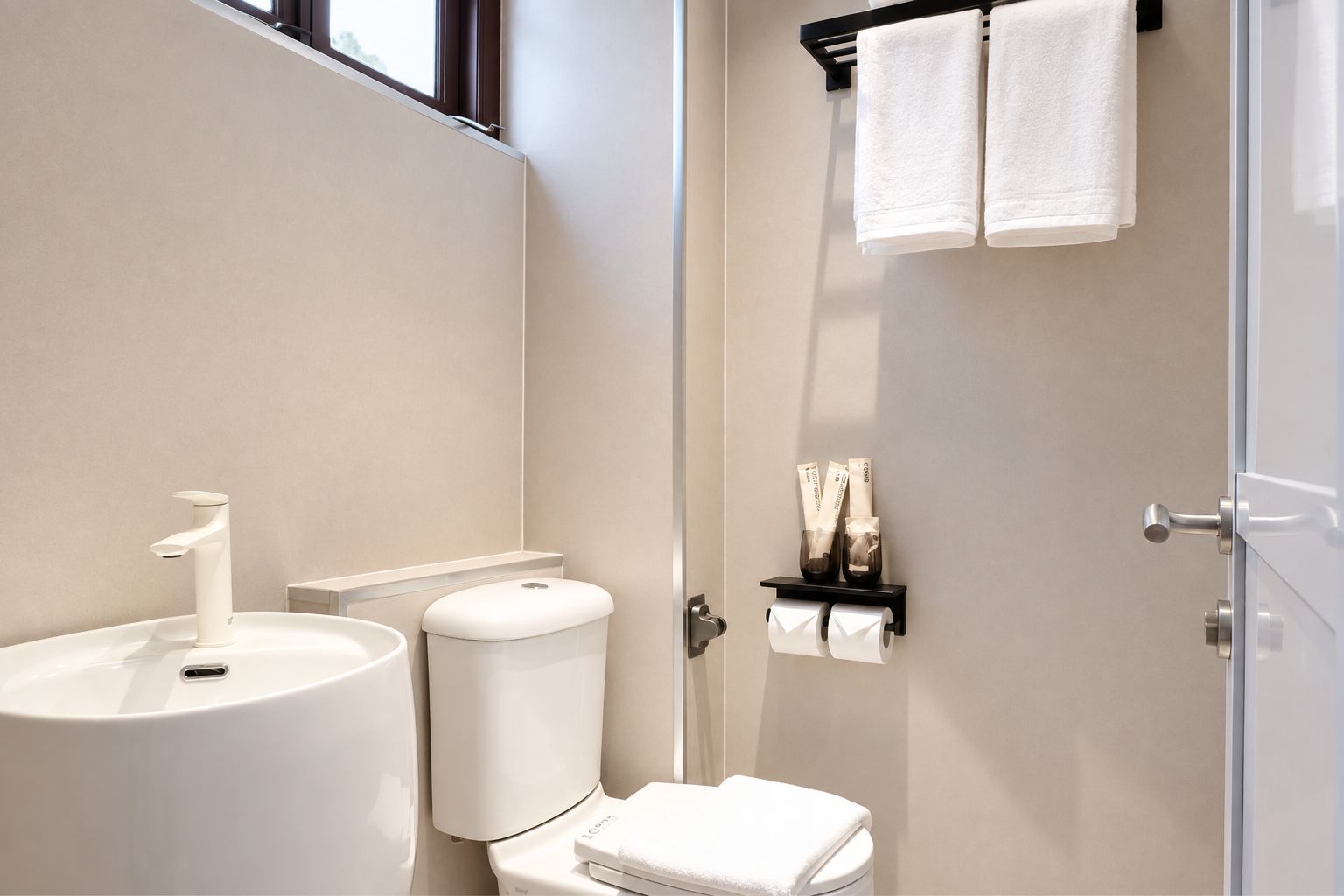 A modern bathroom with a sink, toilet, and towel rack.