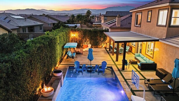 A residential backyard with a swimming pool, outdoor seating, and a covered patio area. - Casa Campo 5BR Desert Oasis w/ Pool, Firepit, & Outdoor Lounge (Indio)