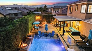A residential backyard with a swimming pool, outdoor seating, and a covered patio area. - Casa Campo 5BR Desert Oasis w/ Pool, Firepit, & Outdoor Lounge (Indio)