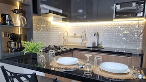 A modern kitchen with two sinks, a microwave, and a gas stove.