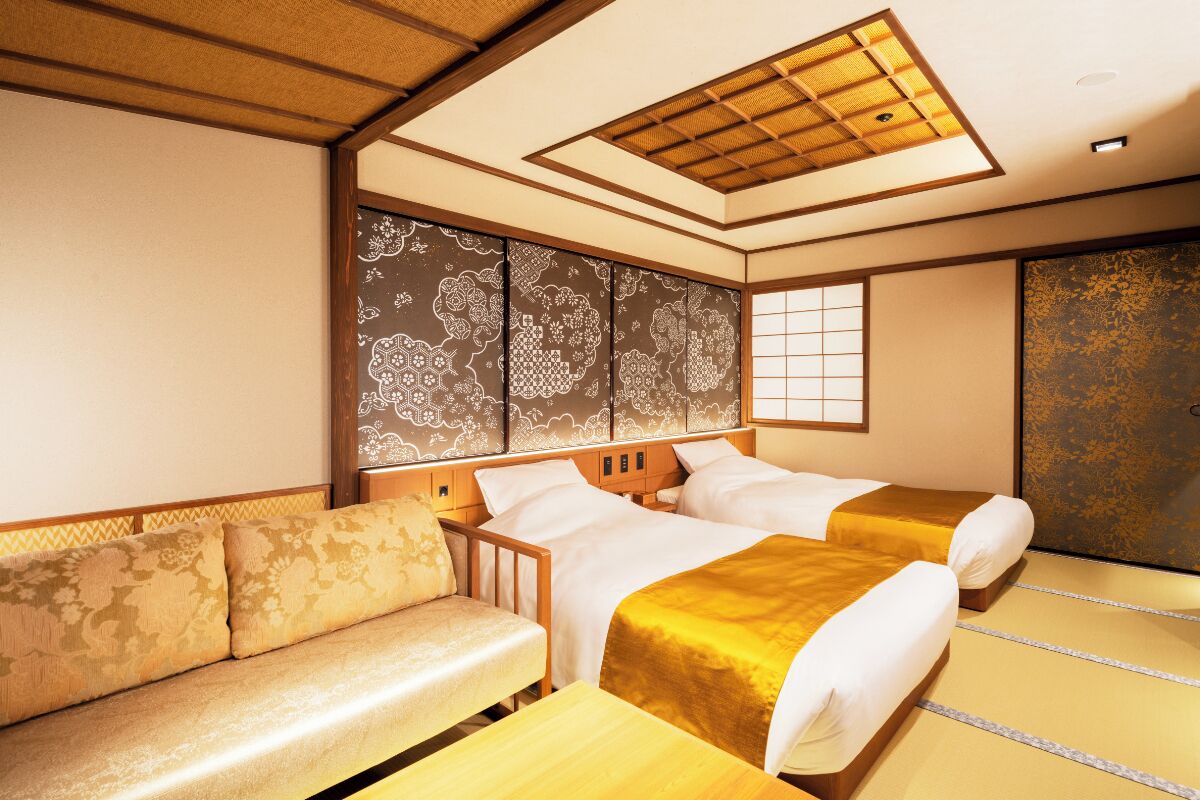 Ein traditioneller japanischer Raum mit Tatami-Boden, einem niedrigen Holzbett, einer gepolsterten Sitzbank und einer Schiebetür.