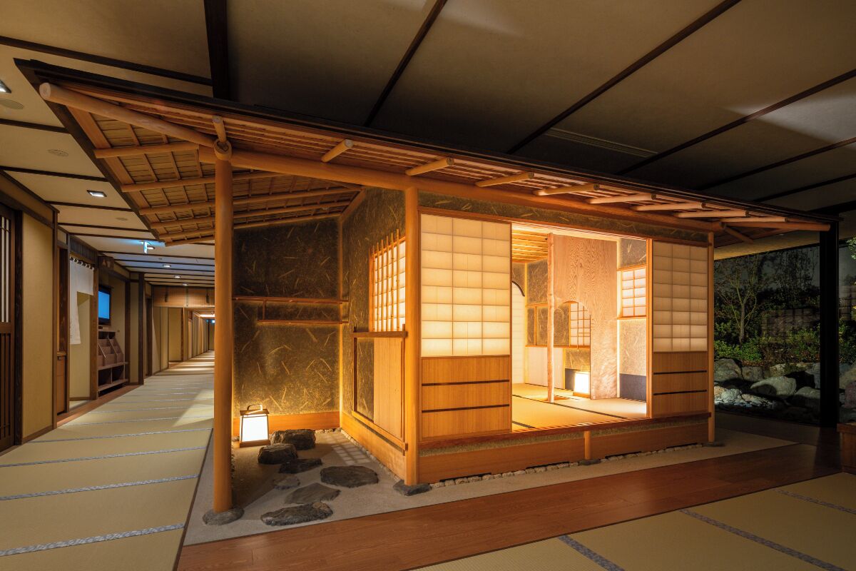 A traditional Japanese room with tatami flooring, sliding doors, and a small stone garden.