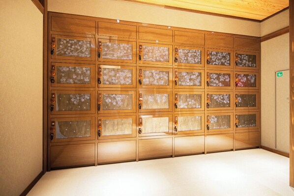 A row of wooden lockers with frosted glass doors, each with a keyhole and a small orange button. - Kyoto Omuro Kadensho(Kyoritsu Resorts) (Kyoto)