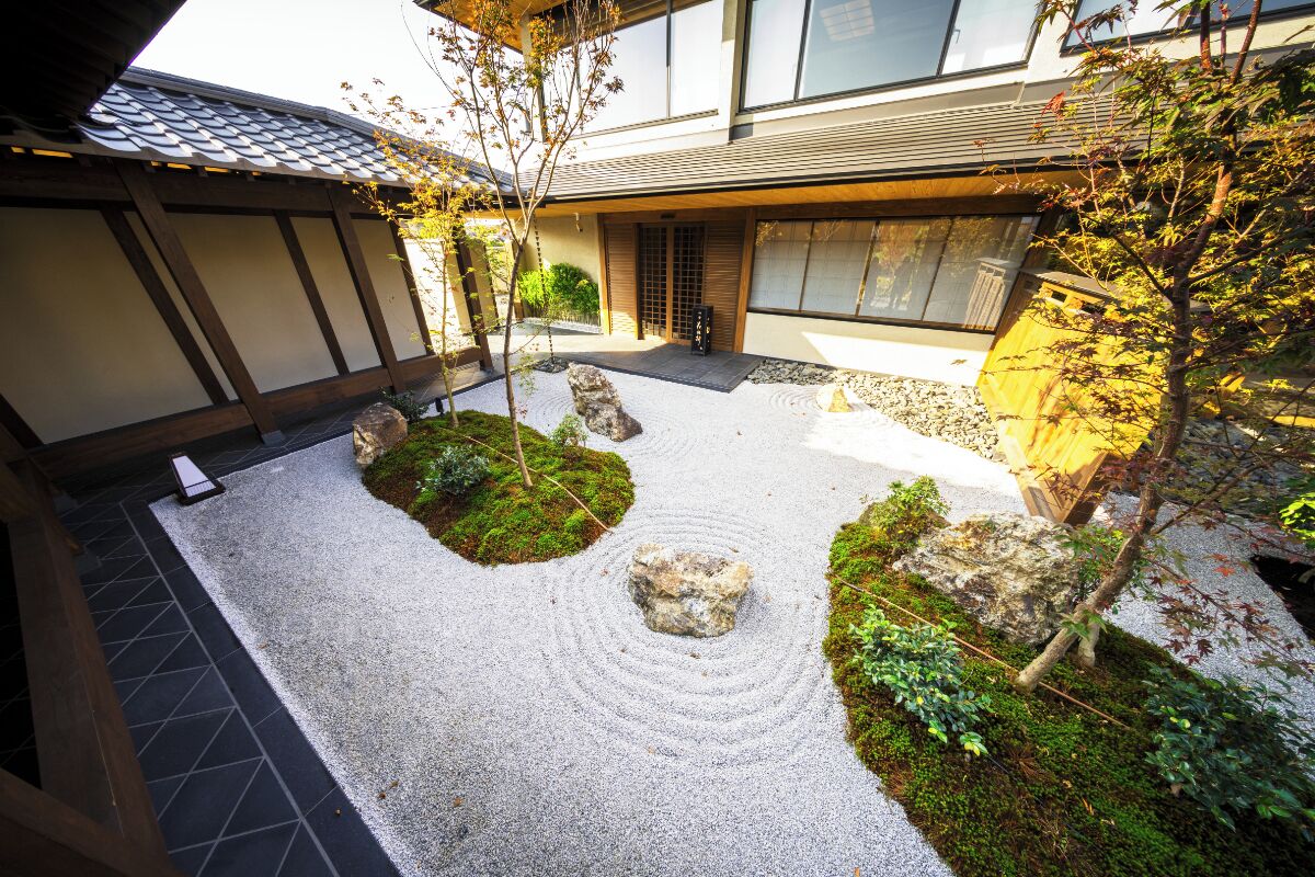 A traditional Japanese garden with a stone path, moss, and rocks.