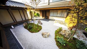 A traditional Japanese garden with a stone path, moss, and rocks.