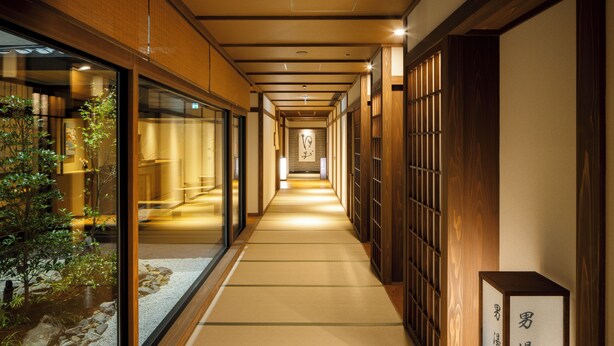A corridor with tatami mats, wooden sliding doors, and a sign indicating a natural hot spring bath for gentlemen. - Kyoto Omuro Kadensho（Kyoritsu Resorts） (Kyoto)