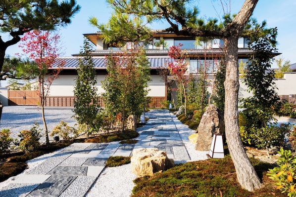 Un edificio tradicional japonés con un sendero de piedra que conduce a la entrada.