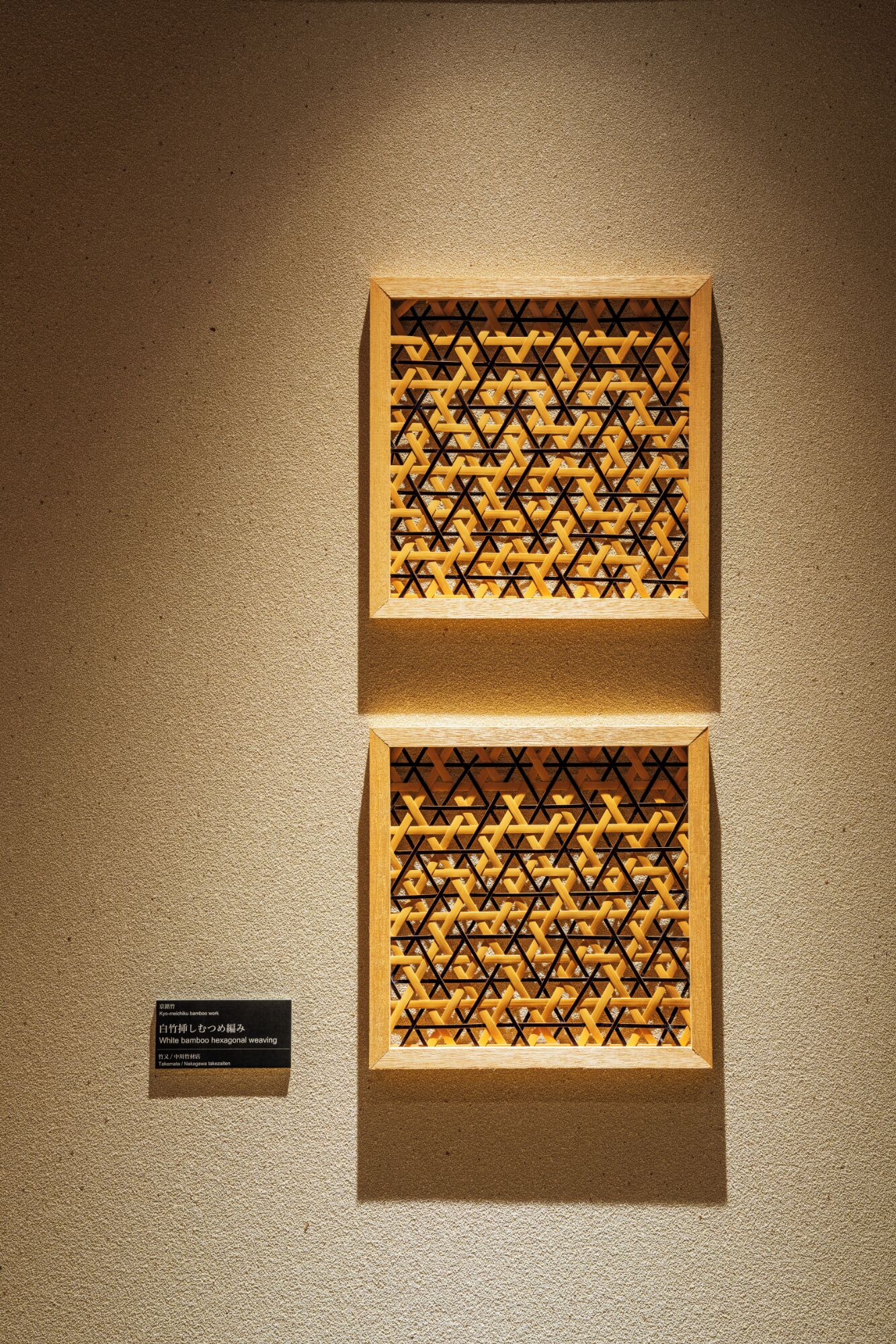 Deux tissages hexagonaux en bambou, encadrés, sont accrochés à un mur à texture.