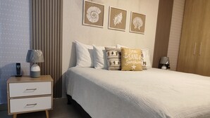 Een keurig opgemaakt slaapkamer met een bed, nachtkastjes en een kledingkast.