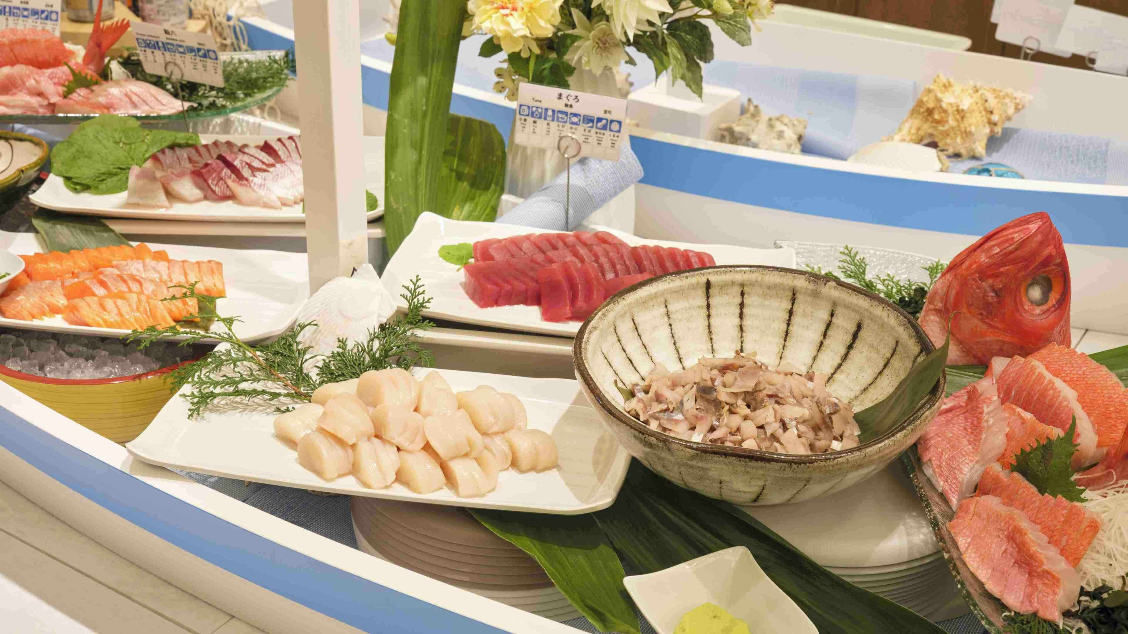 Variedad de mariscos expuestos en una barra, incluyendo diferentes tipos de pescado y mariscos.