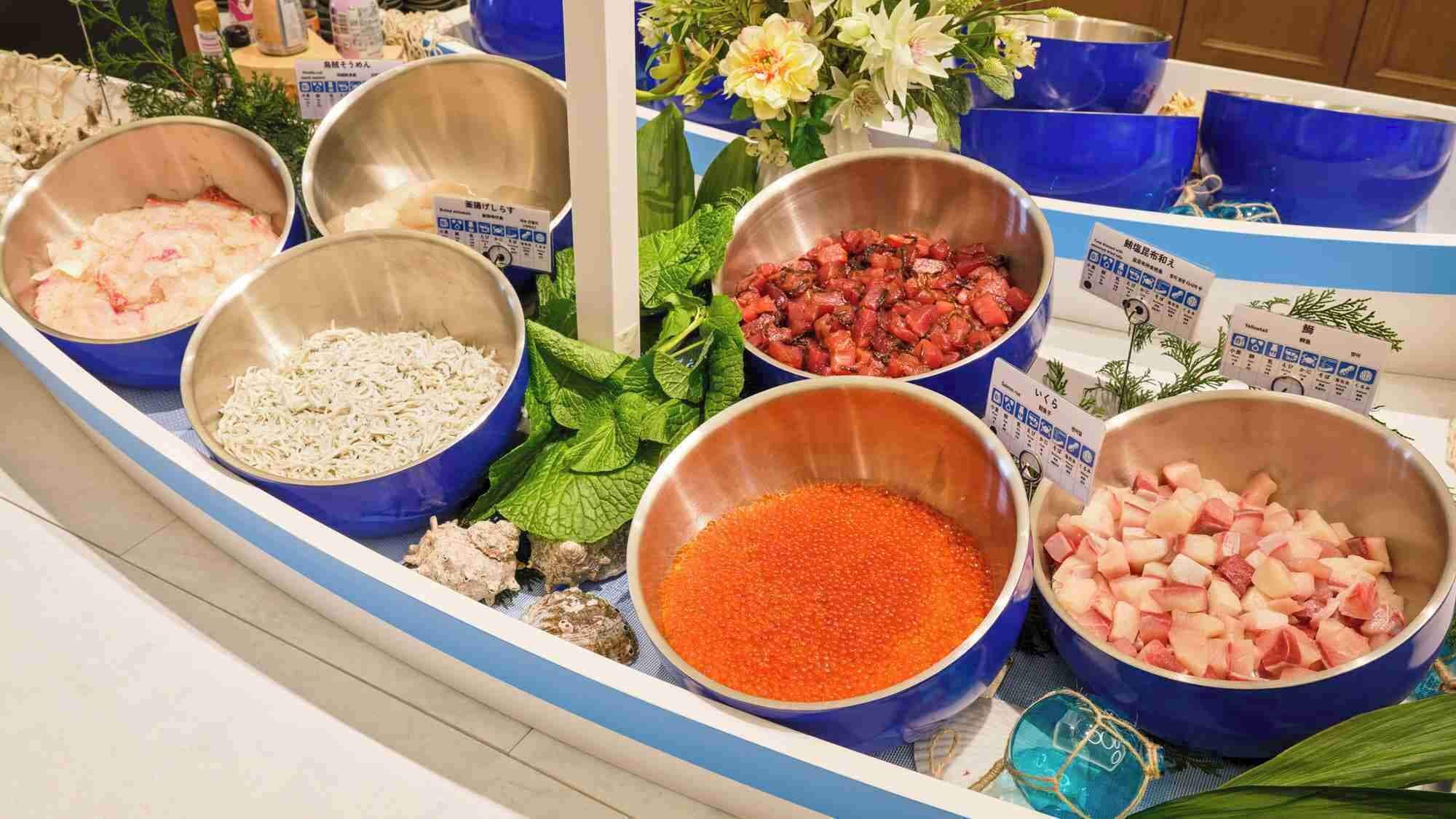 A buffet with various food items in bowls, including noodles, meat, and vegetables.