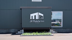 A modern building with a sign for JR Mobile Inn in Furano. - JR Mobile Inn Furano (Furano)