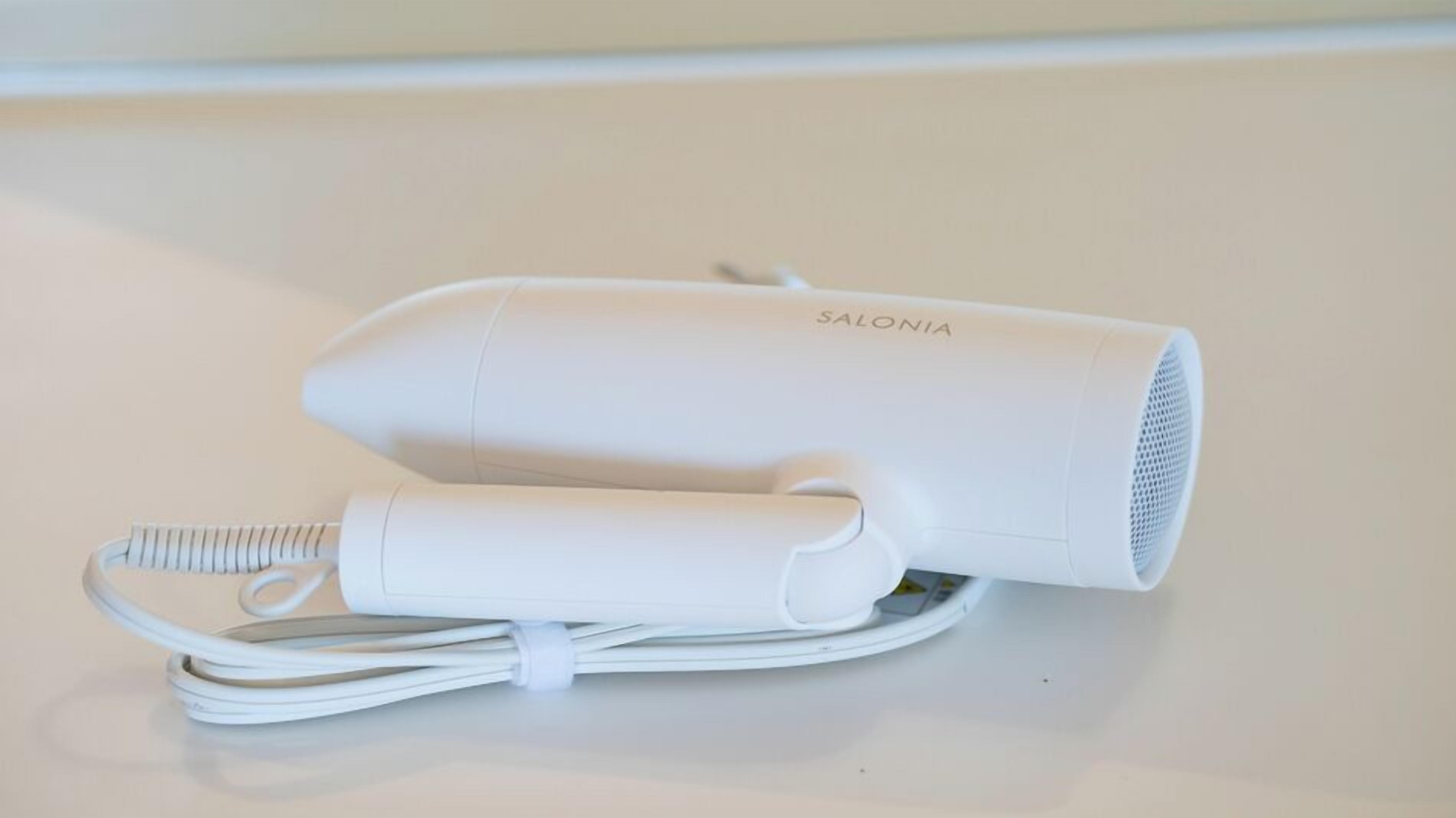 Ein weißer Haartrockner mit Kabel und Netzteil.