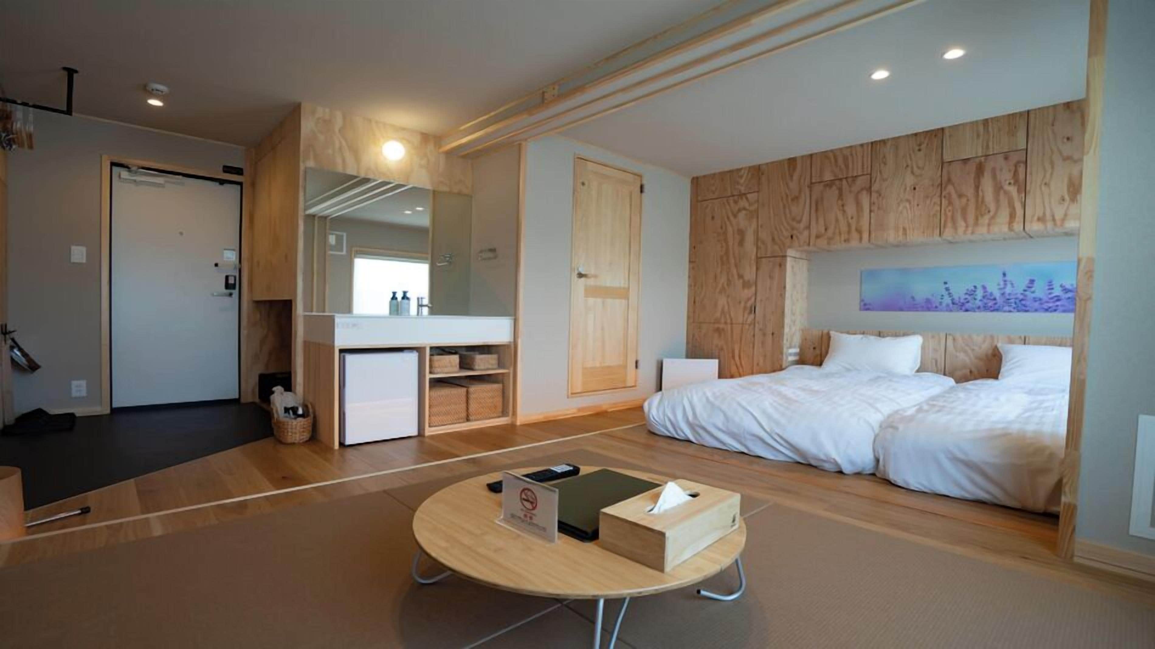 Habitación de hotel moderna con cama, un escritorio pequeño, un espejo y vistas a la ciudad.