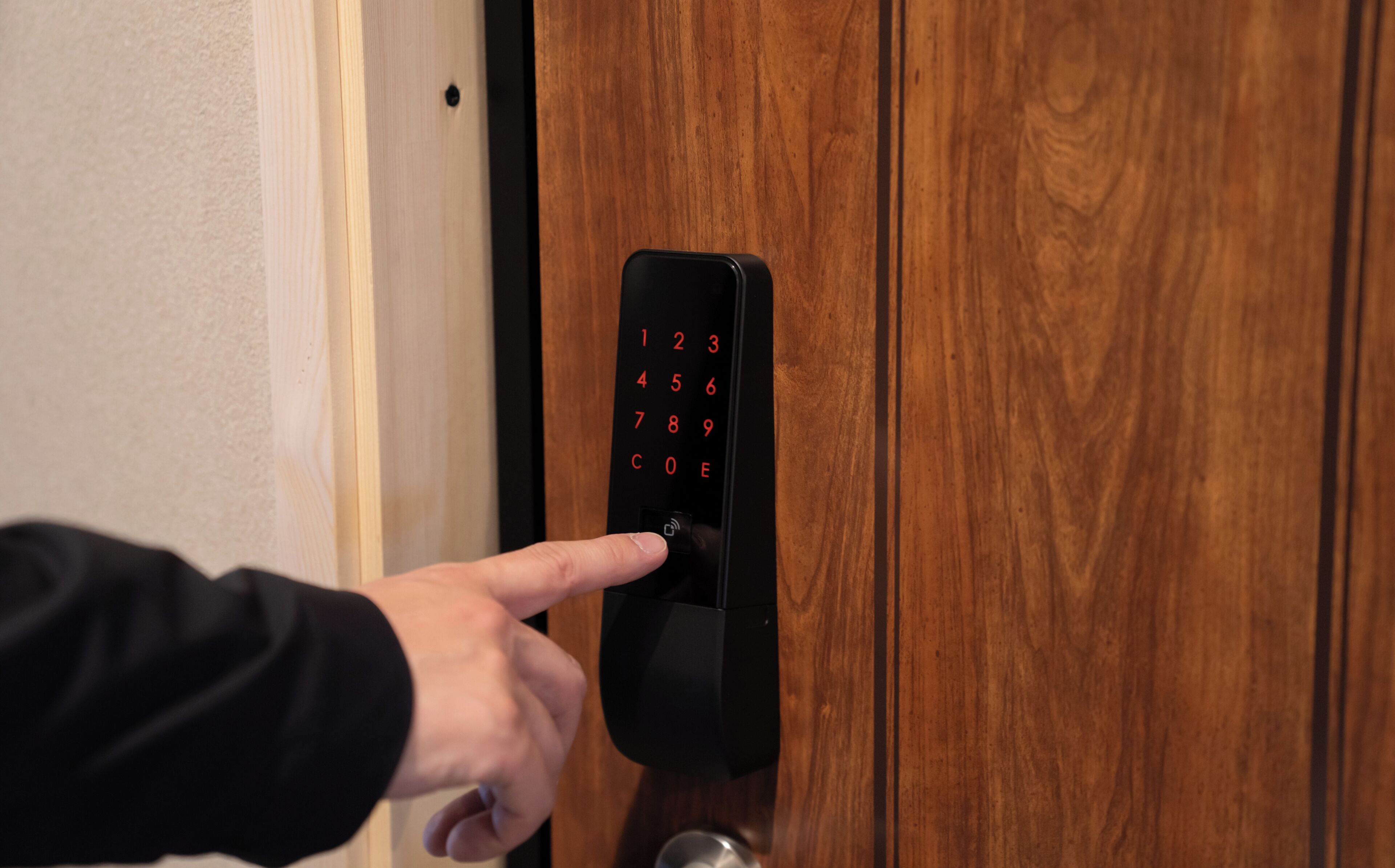 A person using a numeric keypad on a door lock.