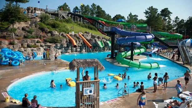 A water park with multiple slides and a swimming pool.
