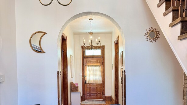 A wooden-floored hallway with a chandelier, a bench, and a chair. - Charming Historical 4BR Home in Central Del Rio (Del Rio)