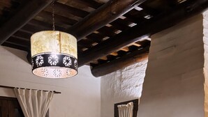Una habitación acogedora con chimenea, una mesa de madera y una lámpara colgante.