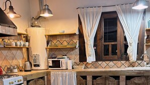 Una cocina con una mesa de comedor, sillas y un calentador de agua.