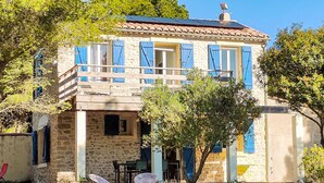 A stone building with blue shutters, a balcony, and outdoor seating. - Mas de Caussagues by Interhome (Sigean)