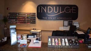 Un área de recepción con un cartel que dice "INDULGE THE SPA AT HORSESHOE".