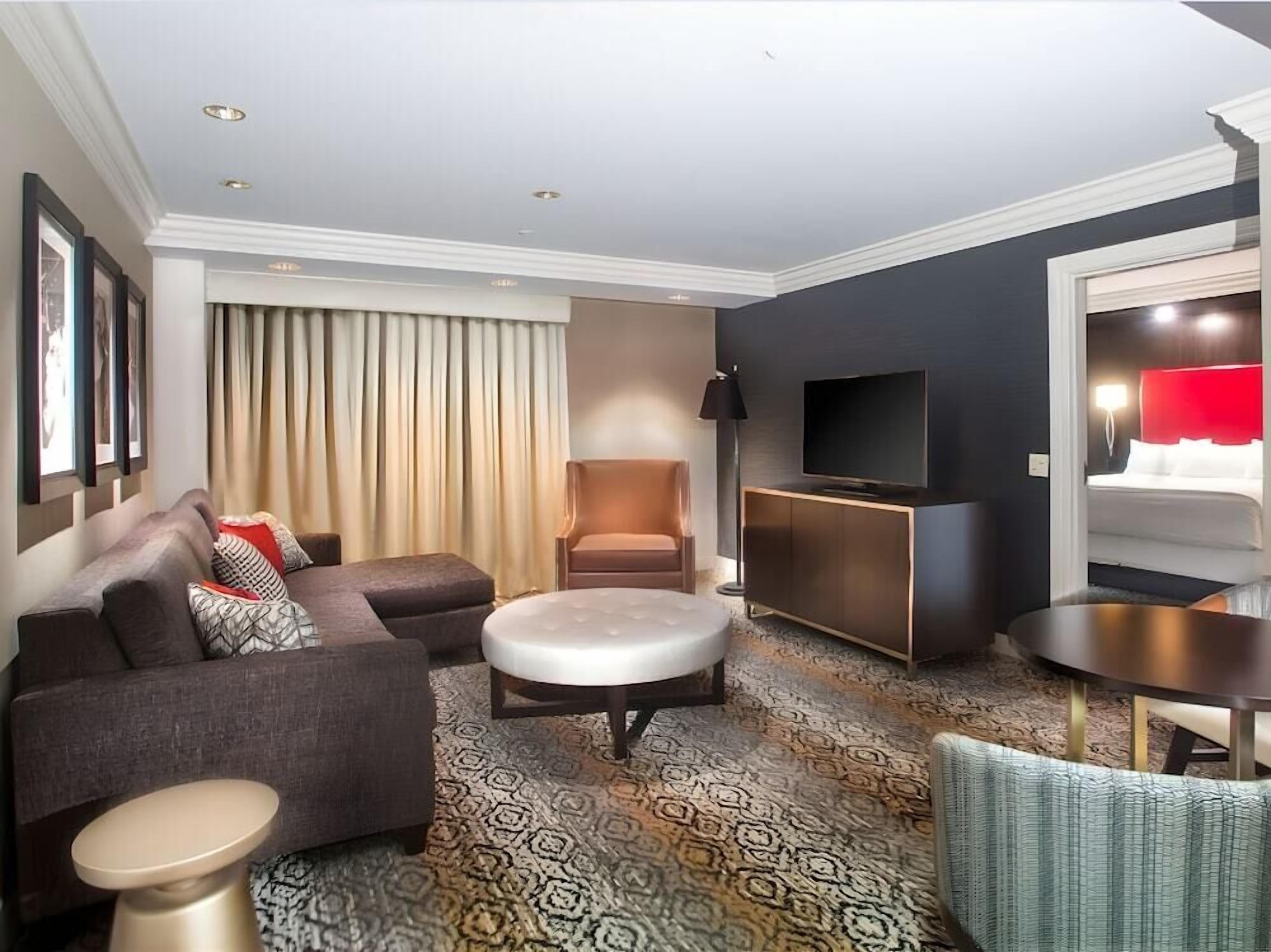 Un salon moderne avec un canapé, un pouf et une petite table.