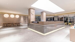 A modern hotel lobby with a reception desk, seating area, and a large chandelier. - Full Season Hotel - PVG  (Shanghai)