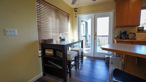 A kitchen with a wooden table, a bench, and a coffee maker. - Charming 2-bedroom apartment with AC in Rainier (Rainier)