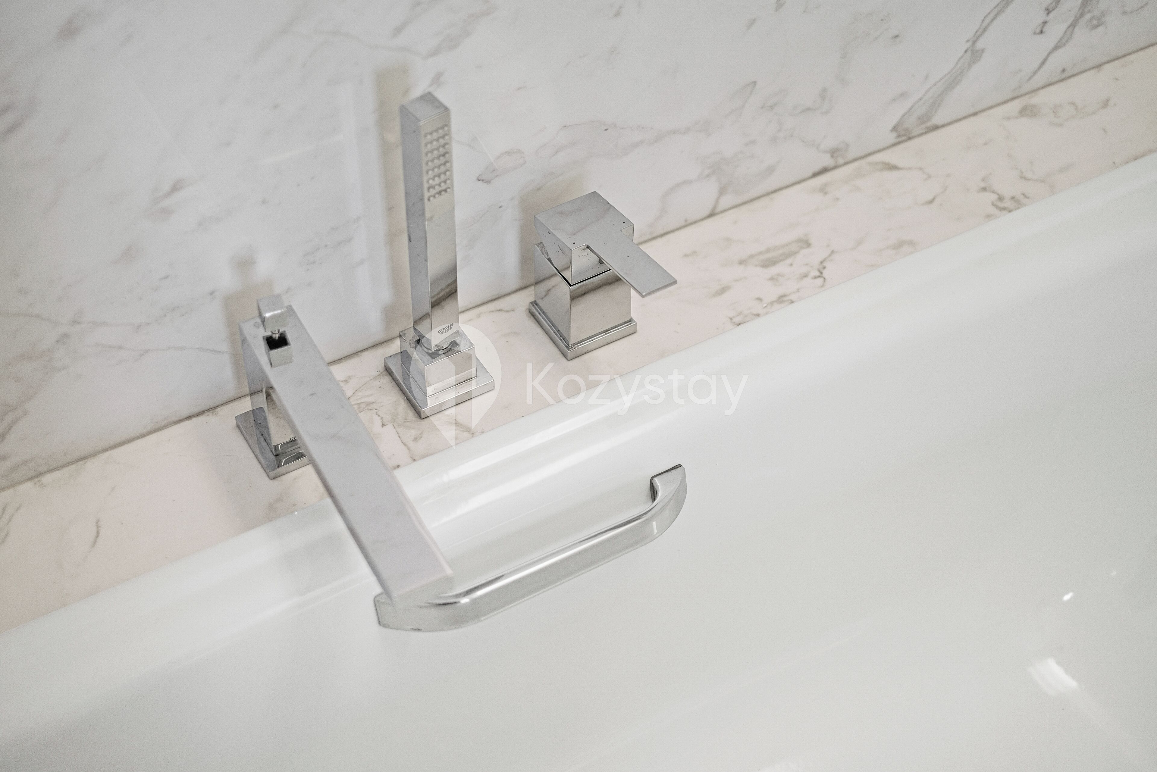A bathroom with a white bathtub, a chrome faucet, and a towel rack.