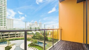 A balcony with a view of a swimming pool and surrounding buildings.