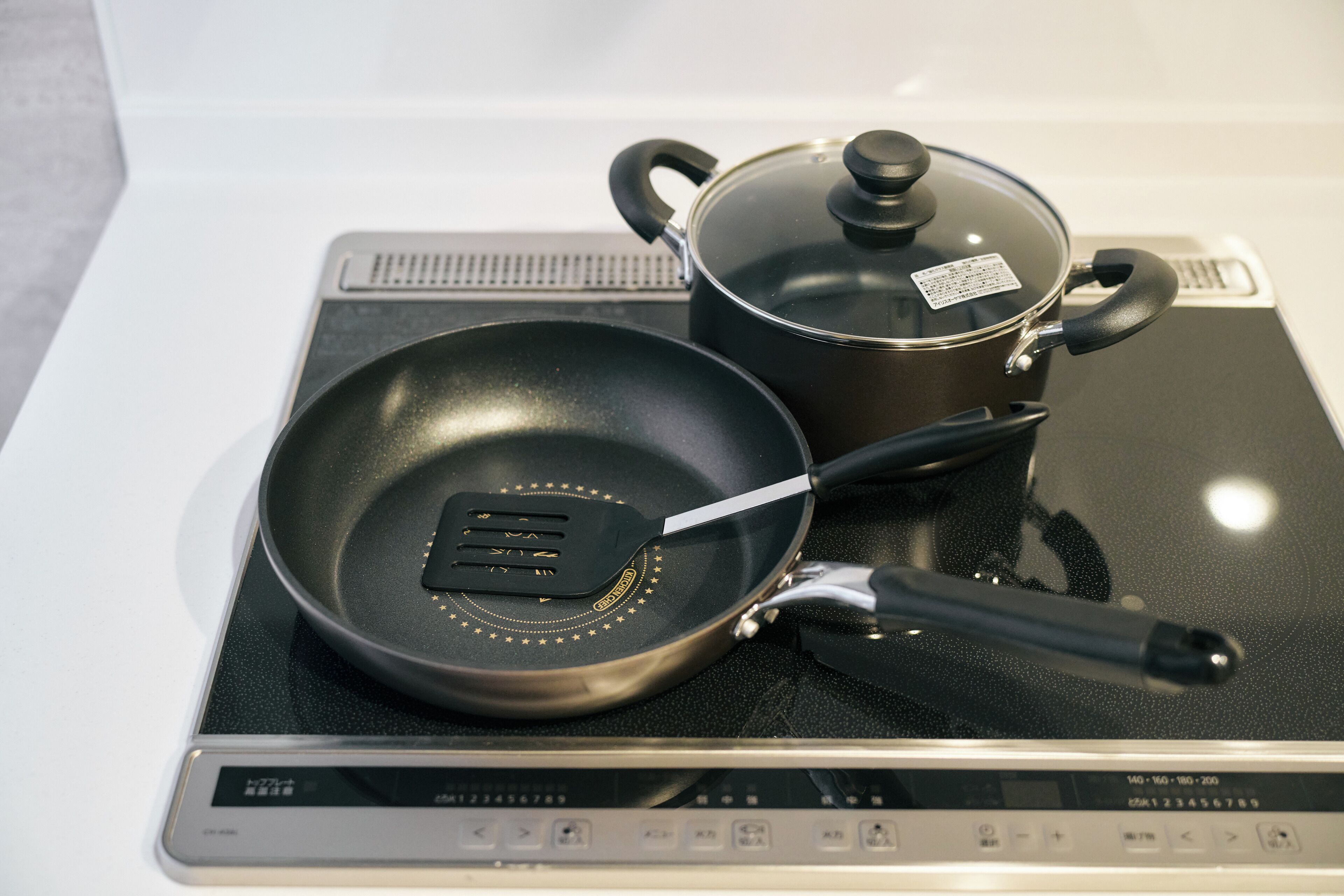 A stovetop with a frying pan and a pot with a lid.
