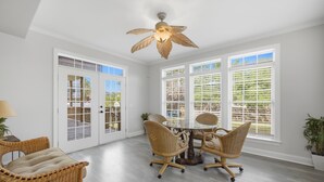 A room with a dining table, four wicker chairs, a ceiling fan, and large windows with blinds. - 4 BR Beach Retreat - 2 Suites - Dogs Welcome (Norfolk)