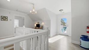 A spacious interior with a white staircase, a chandelier, and a view to an outdoor patio. - 4 BR Beach Retreat - 2 Suites - Dogs Welcome (Norfolk)