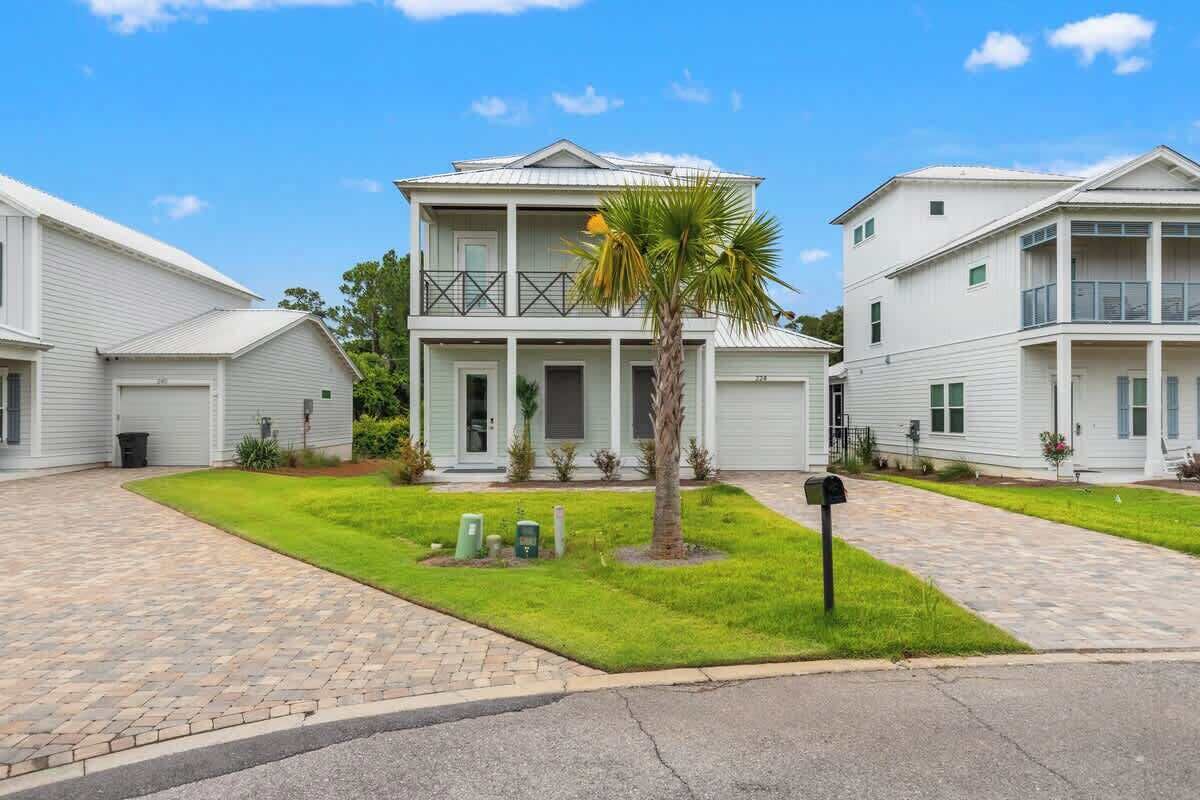 A two-story residential building with a front porch, a small lawn, and a mailbox.