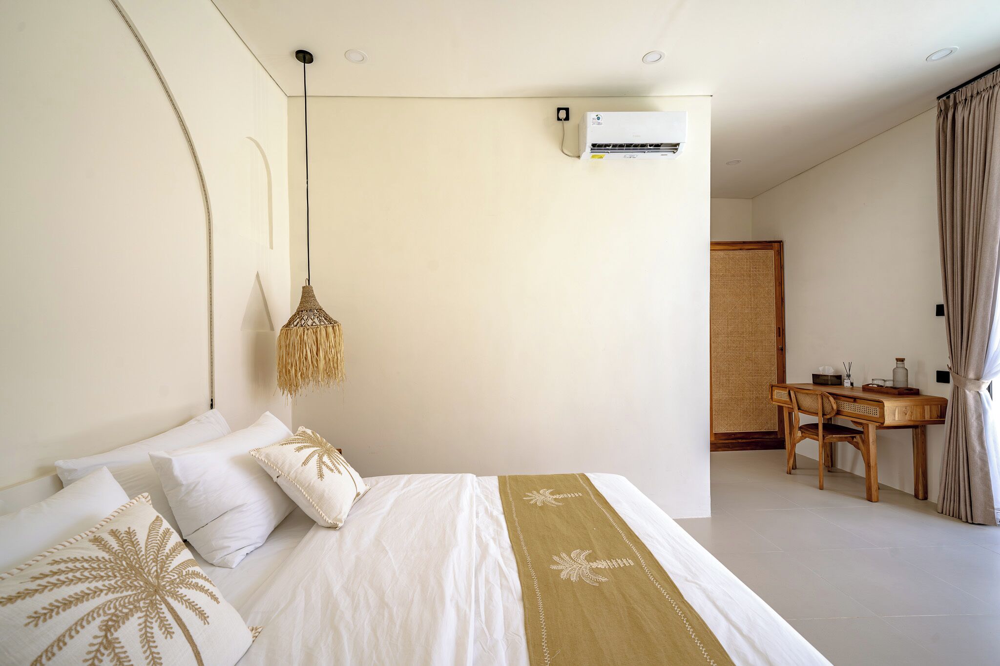 Ein Schlafzimmer mit einem Bett, einer Nachttischlampe und einem kleinen Schreibtisch mit Stuhl.