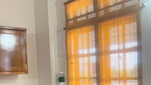 A kitchen with wooden cabinets, a sink, a coffee maker, a toaster, and a window with blinds. - Cozy 1-bedroom apartment in adorable Tobago with AC, WiFi (Tobago)