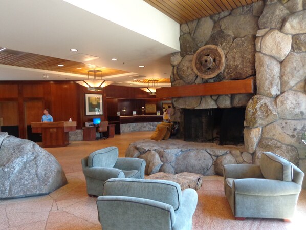A lobby with a stone fireplace, seating area, and a reception desk.