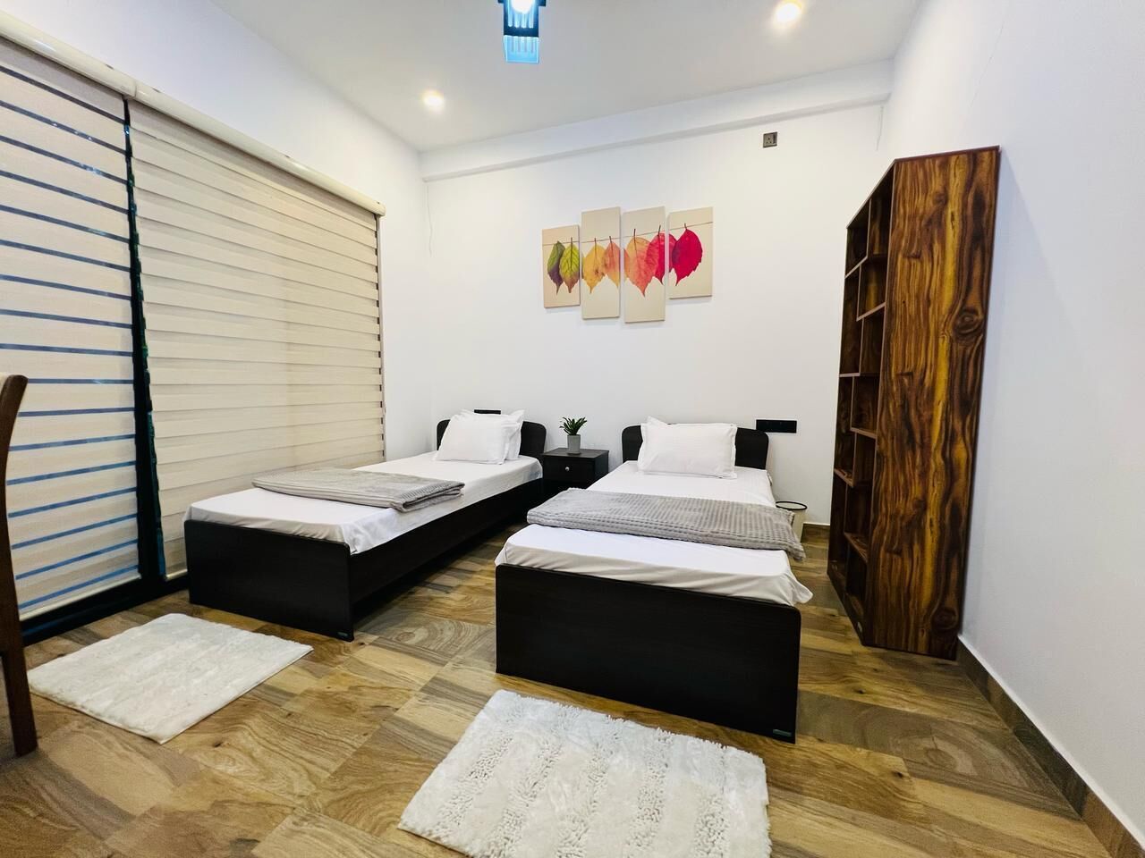 Une chambre moderne avec deux lits, une grande armoire et une porte coulissante.