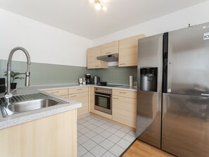 A modern kitchen with stainless steel appliances, a built-in oven, and a coffee maker. - Light-flooded vacation apartment Felix - your Allgäu dream in a quiet idyll (Weitnau)