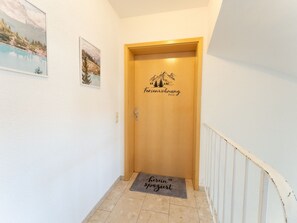A hallway with a wooden door labeled 'ferienwohnung Felix' and a doormat with 'hierin spaziert' text. - Light-flooded vacation apartment Felix - your Allgäu dream in a quiet idyll (Weitnau)