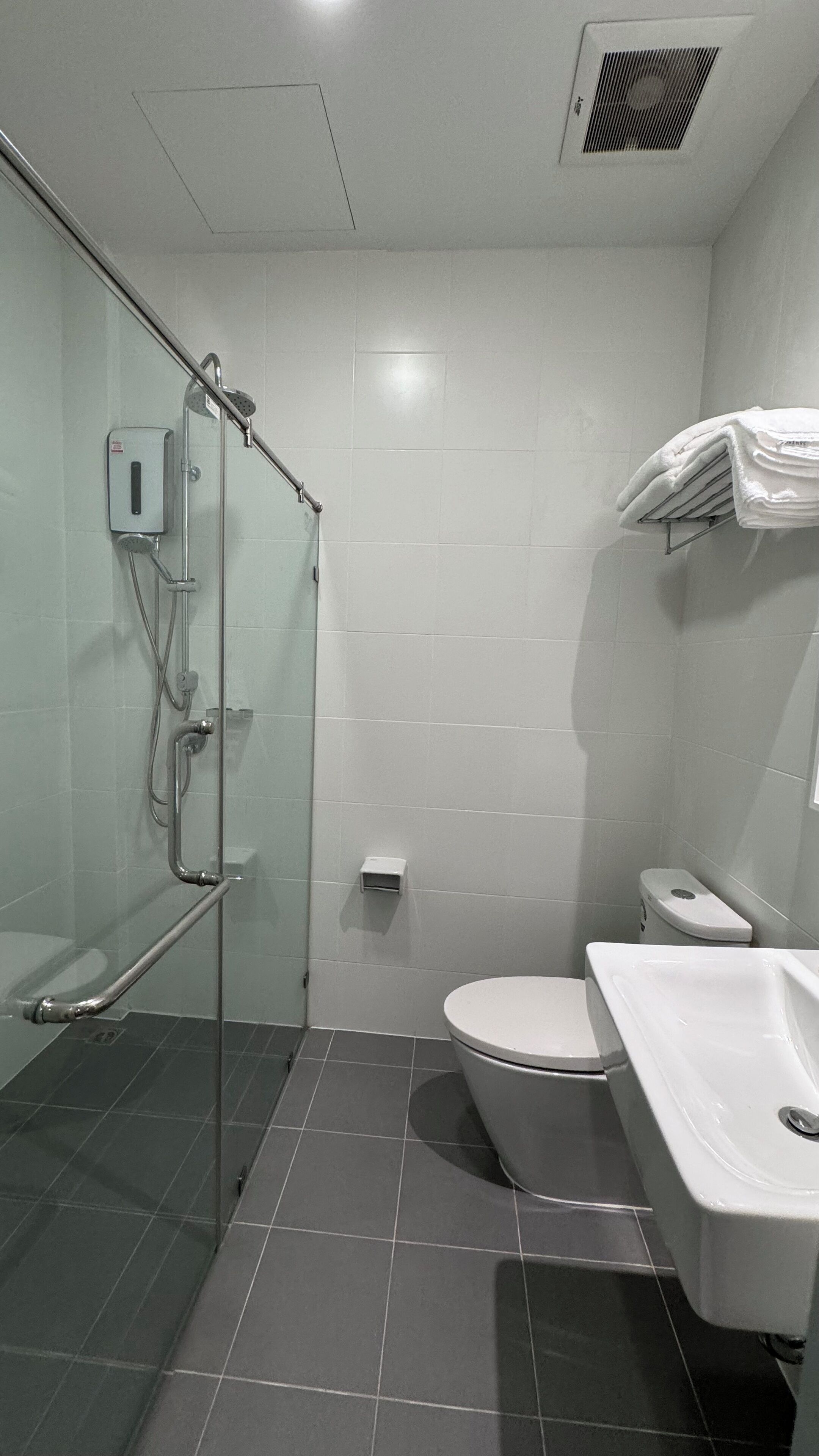 A bathroom with a glass-enclosed shower, a white toilet, and a sink.