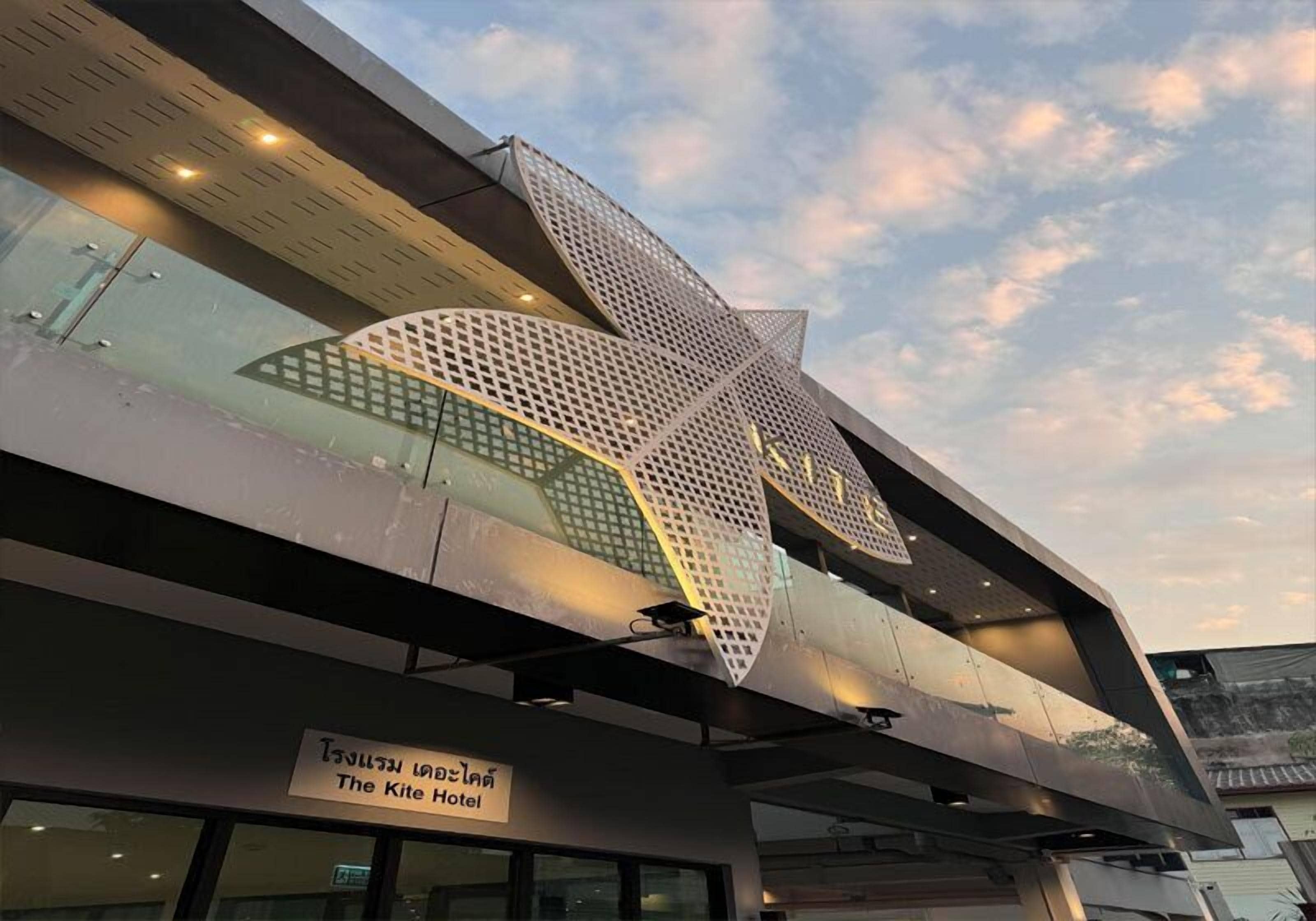 A modern building with a unique geometric facade and a sign indicating it is The Kite Hotel.