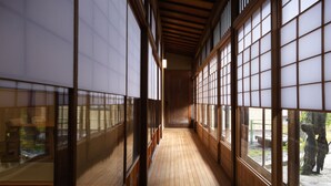 A corridor with wooden flooring and large shoji screens on both sides. - mameya (Sasayama)