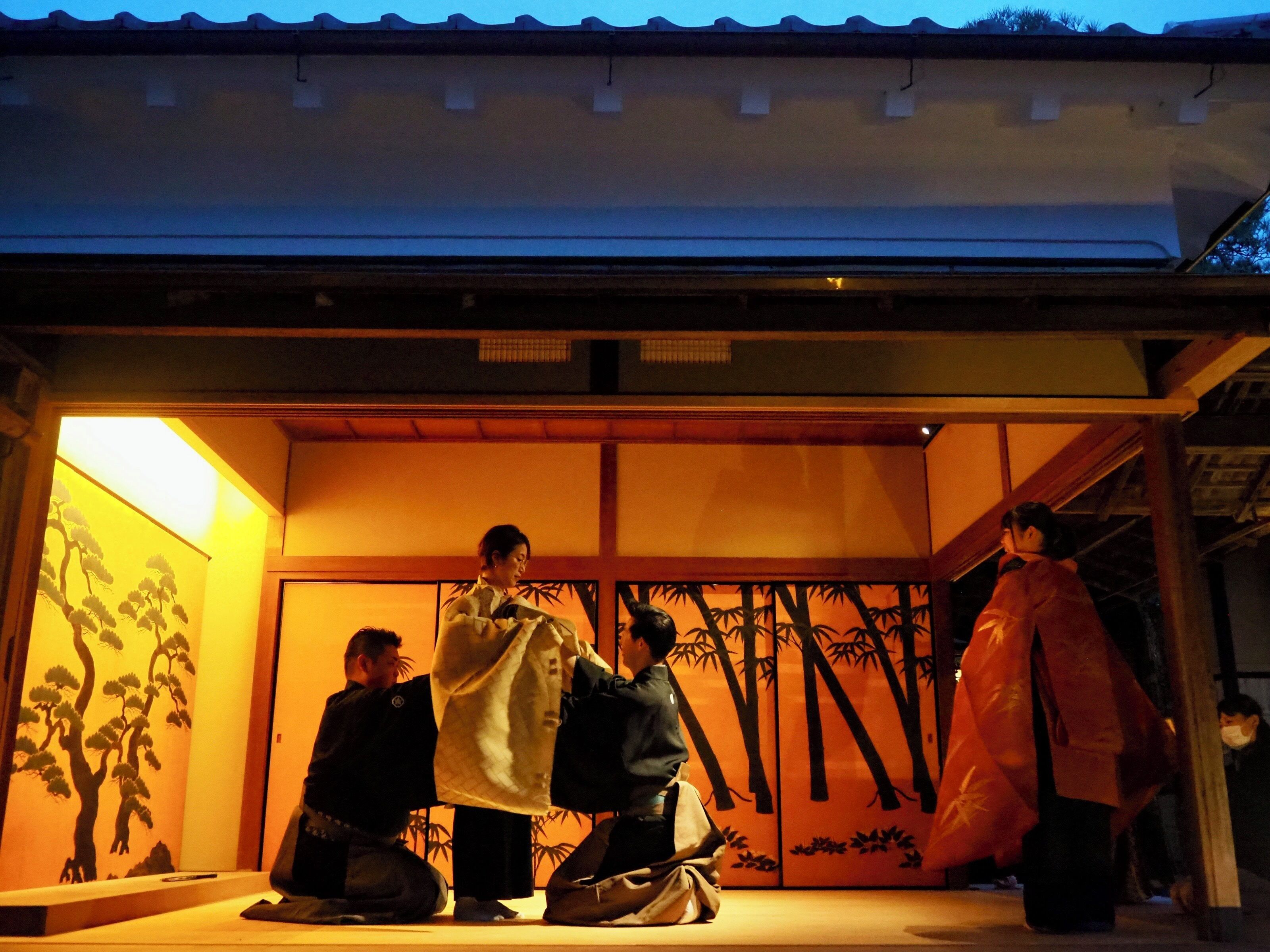 A traditional Japanese building with tatami mat flooring and a sliding door with a tree mural.